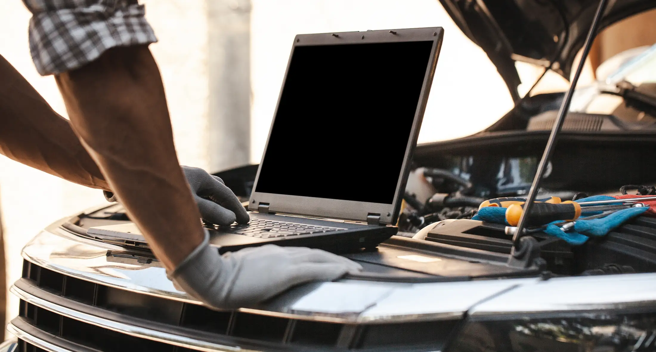 Der Mechaniker nutzt einen Laptop, um Fehler bei Motorkontrollen aufzuzeichnen